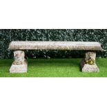 A reconstituted stone curved garden bench, on a pair of recumbent lion supports,