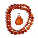 A single row necklace of graduated translucent amber beads on an oval filigree clasp,