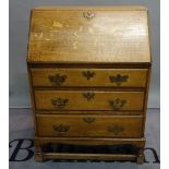 An early 20th century bureau with three long drawers on block supports, 74cm wide x 104cm high.