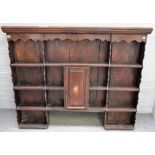 An 18th century French oak enclosed four tier plate rack, centred by cupboard,