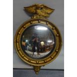 'AISOWIA' ; A Regency style giltwood convex wall mirror with eagle crest surmount,