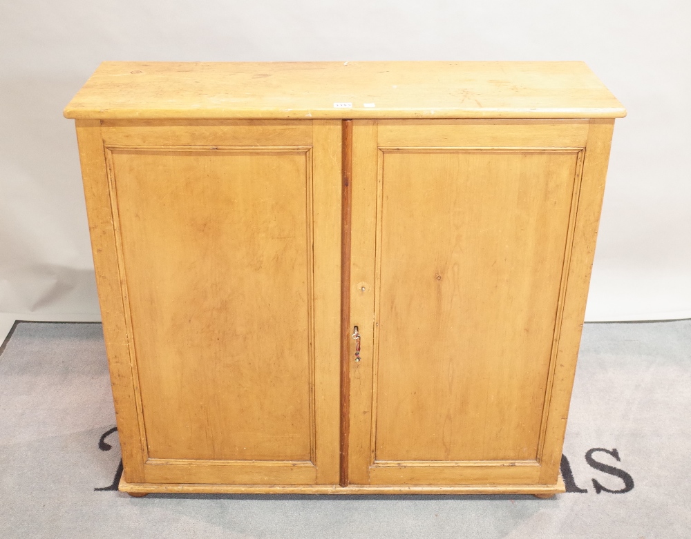 An early 20th century pine side cupboard on bun feet, 101cm wide x 94cm high.