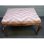 A Louis XV style gilt framed rectangular footstool of serpentine outline, on scroll supports,