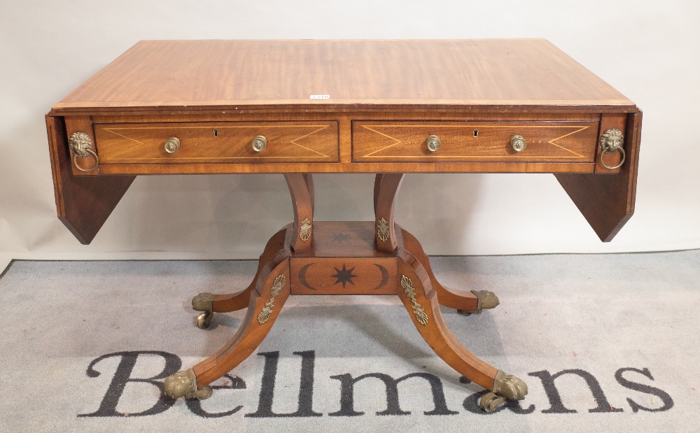 A late 19th century mahogany and ebony inlaid sofa table on four outswept supports,