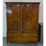 A George III mahogany linen press with moulded cupboard doors over two short and one long drawer,