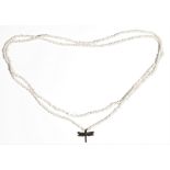 A single row necklace of freshwater seed pearls, the front with a diamond set dragonfly pendant,