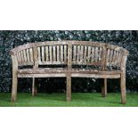 A teak semi-elliptic garden bench of slatted construction, 160cm wide x 86cm high,