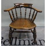 A Victorian elm seated smoker's bow armchair on turned supports, 68cm wide x 73cm high.