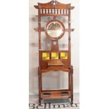 An Art Nouveau mahogany hall stand, inset with a circular mirror and three floral tiles, 86.