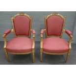 A pair of Louis XVI style gilt framed open armchairs with ribbon tied crest and bow seat on fluted