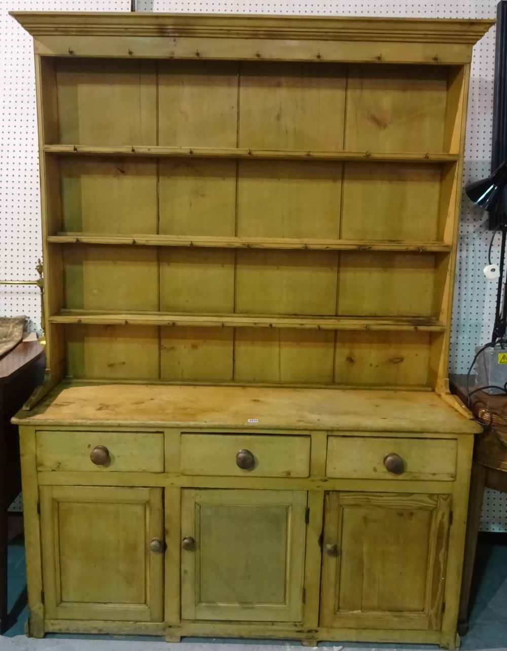 An early 20th century pine kitchen dresser with three tier plate rack over three drawer cupboard