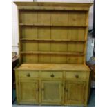 An early 20th century pine kitchen dresser with three tier plate rack over three drawer cupboard