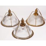 A set of three modern brass and holophane glass industrial ceiling lights, 34cm high (3).