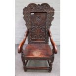 A mid-17th century and later carved oak panel back Wainscot open armchair on block and turned