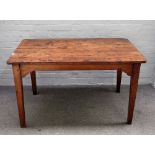 An early 19th century French figured oak plank top kitchen table, on tapering square supports,