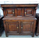 A 17th century oak court cupboard, with two pairs of raised panel doors on stile feet,