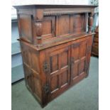 A 17th century oak court cupboard with two pairs of panelled cupboards flanked by turned cloumns,
