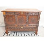 An 18th century style oak mule chest with carved foliate decoration,