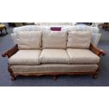 An early 20th century carved walnut framed double bergere three piece suite, to comprise; a sofa,