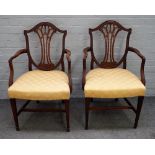 A pair of George III mahogany shield back open armchairs on tapering square supports,