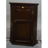 A 19th century oak hanging corner cupboard with panelled door, 65cm wide x 86cm high.