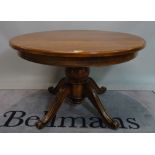 A Continental oak circular extending dining table, with turned column and two extra leaves,