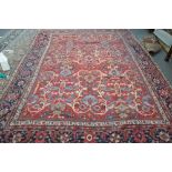 A Mahal carpet, Persian, the madder field with an allover palmette and floral vine design,