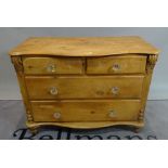 An early 20th century pine serpentine chest of two short and two long drawers on turned supports,