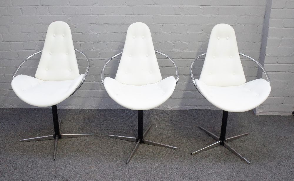 In the manner of Arne Jacobson; a set of three cream leather upholstered dining chairs,