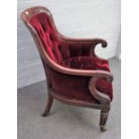 A William IV mahogany framed library bergere with scroll arms and tapering reeded supports,