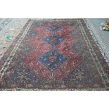 A Shiraz carpet, Persian the madder field with three indigo diamonds,