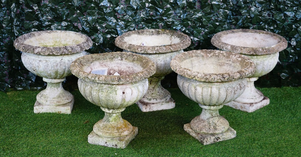 A set of five reconstituted stone circular jardinieres with semi-fluted bodies on turned socles,