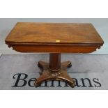 A Victorian mahogany foldover tea table on octagonal turned column and quatrefoil base,