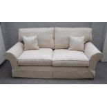 A modern three piece suite with loose cream upholstery to comprise a sofa, 207cm wide x 78cm high,