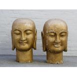 A pair of large gold painted Buddhistic style heads with elongated ears, each 82cm high.