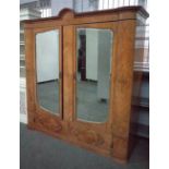 A late 19th/early 20th century satinwood wardrobe with a pair of bevelled glazed doors over a two