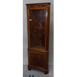An Edwardian mahogany inlaid floor standing corner cabinet with astragal glazed door,