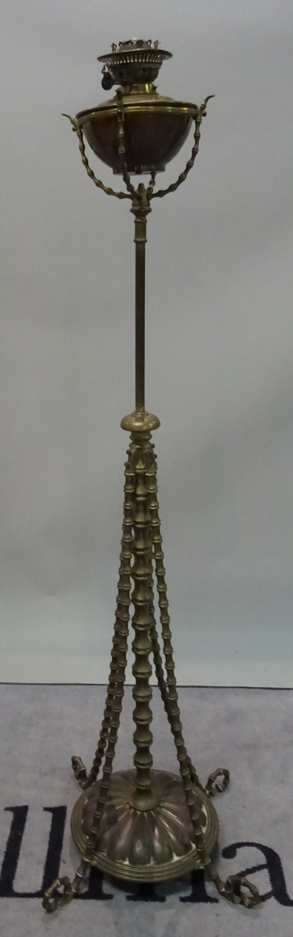 An early 20th century brass standard lamp with faux bamboo supports, 147cm high,