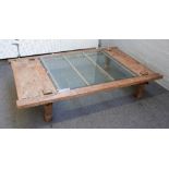 A large glass inset rectangular coffee table constructed with 19th century Eastern reclaimed