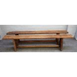 A pair of 19th century French oak benches, each on four square supports united by stretcher,