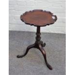 A small George III mahogany wine/kettle stand, the dished pie crust top on a tripod base,