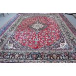 An Esfahan carpet, Persian, the madder field with a bold black and ivory medallion,