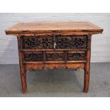 A late 19th century Chinese elm side table with pair of drawers over pierced frieze on block