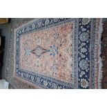 A Persian rug, the pale madder field with two bold palmettes and floral sprays,