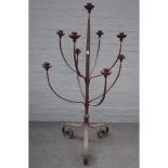 A large modern wrought iron nine branch floor standing candelabra, on three scroll supports,