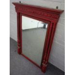 A red painted parcel gilt rectangular mirror with gadrooned frieze flanked by fluted columns,