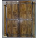 A pair of early 20th century French walnut and strap iron bi-fold doors flanked by pine turned
