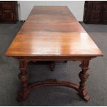 A 19th century German oak extending dining table on carved baluster supports united by shaped