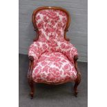 A Victorian mahogany framed spoonback easy armchair, with serpentine seat on scroll supports,
