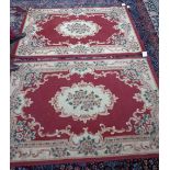 Two machine made red and cream floral rugs, each 170cm x 120cm.